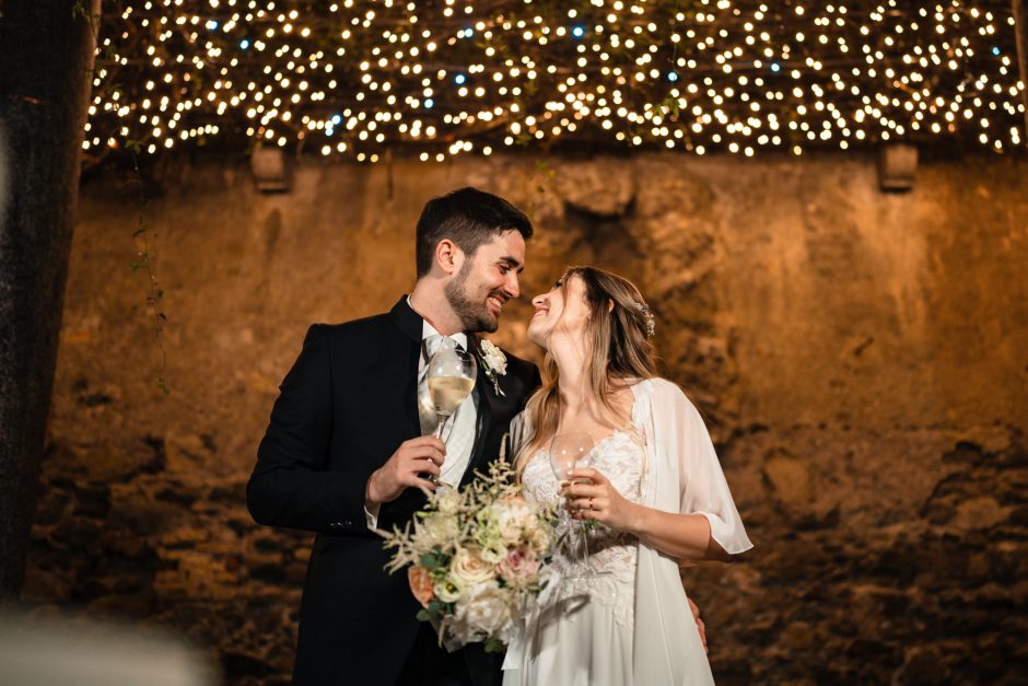 Primo piano di Marika e David sorridenti, illuminati dalle luci serali a Villa Parravicino Sossnovsky. Fotografo matrimonio varese Paolo Lamperti.