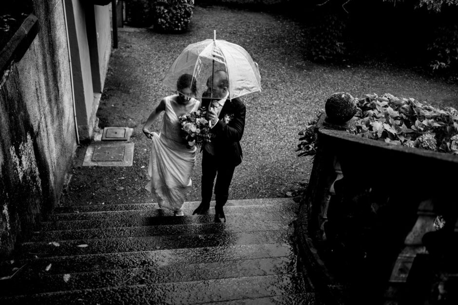 Ritratto romantico in bianco e nero degli sposi con ombrello a Villa Morotti